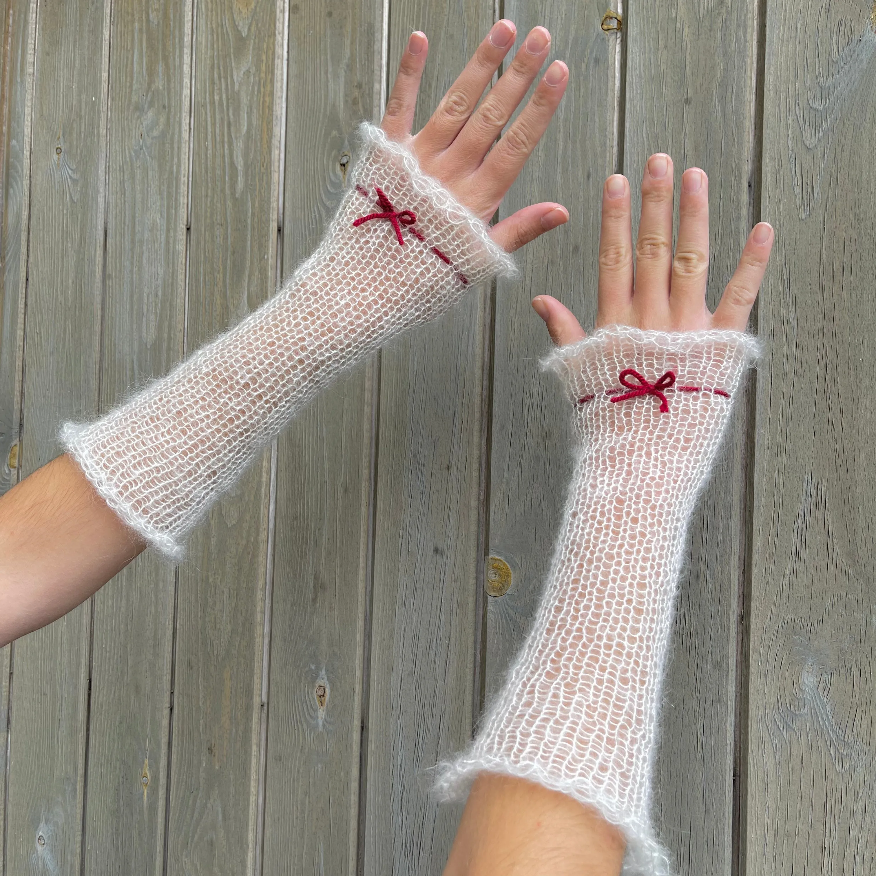 Handmade knitted mohair hand warmers in cream with dark red bow