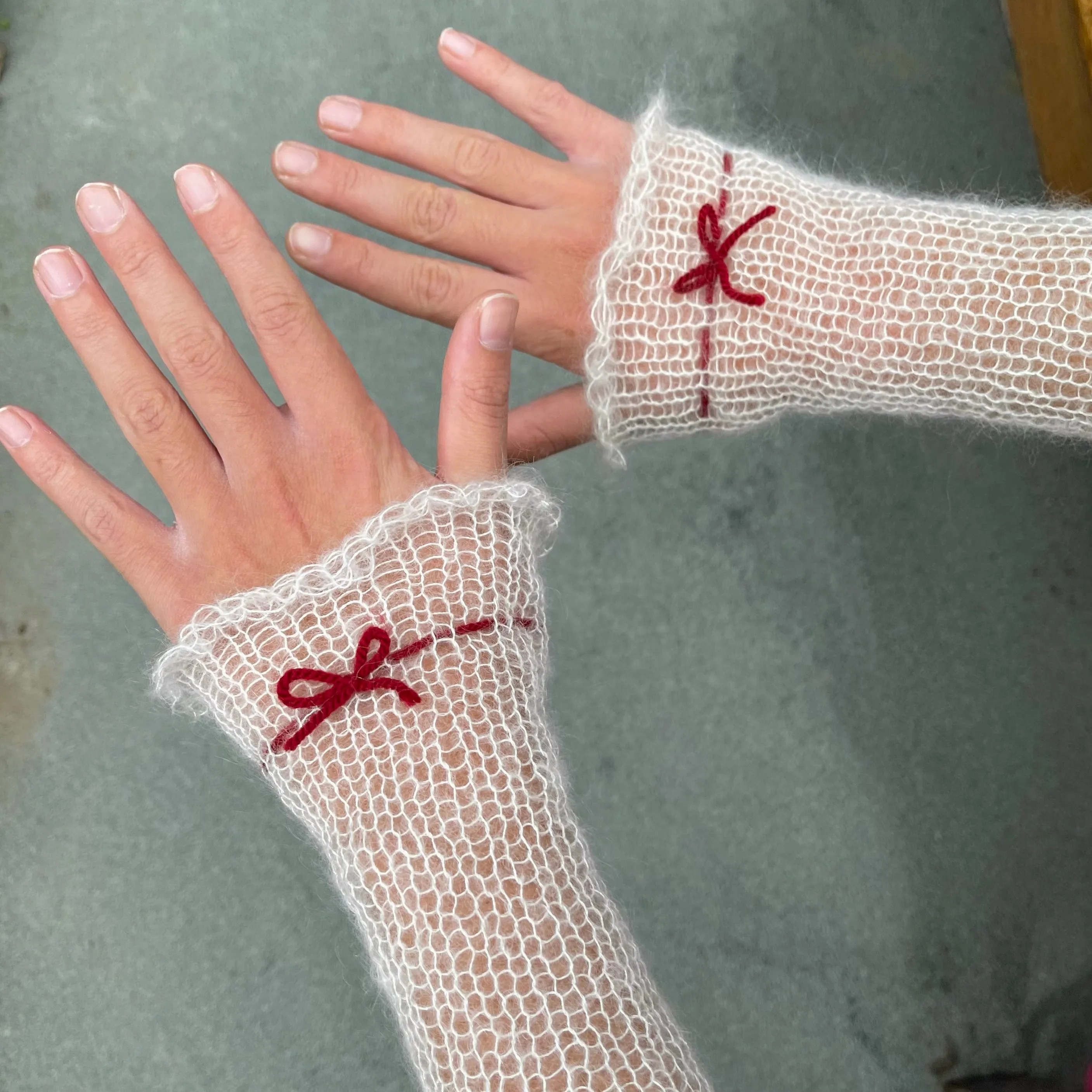 Handmade knitted mohair hand warmers in cream with dark red bow