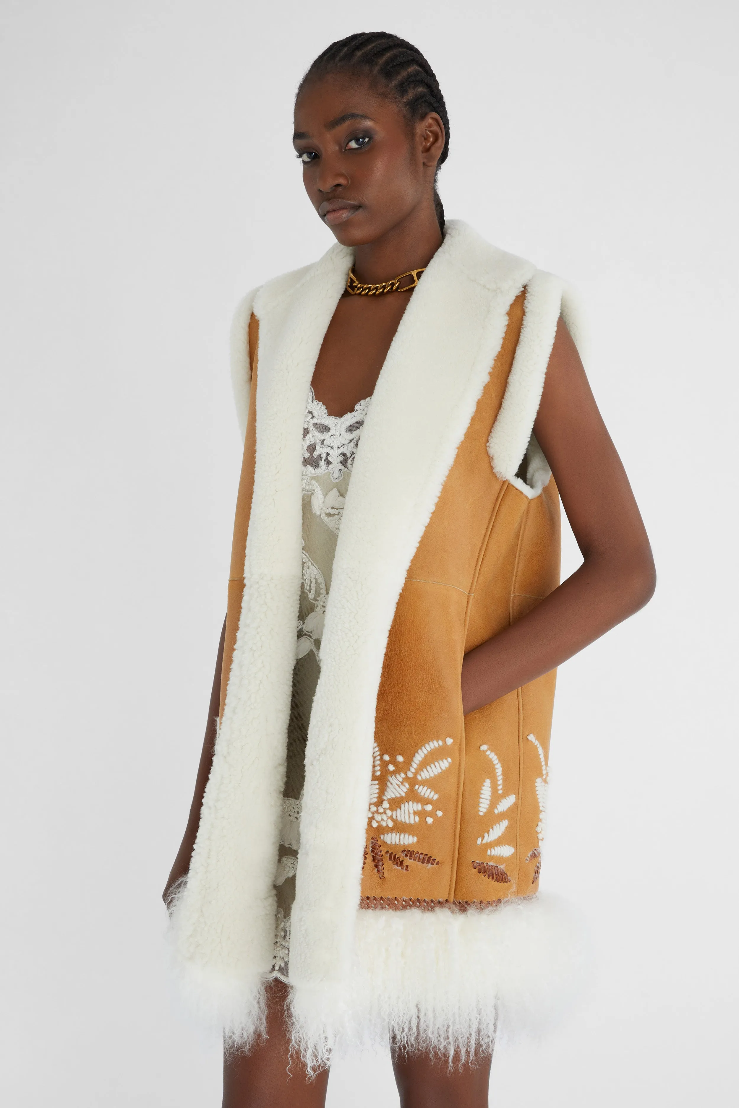 Shearling long waistcoat with handmade embroidery and fur on the bottom